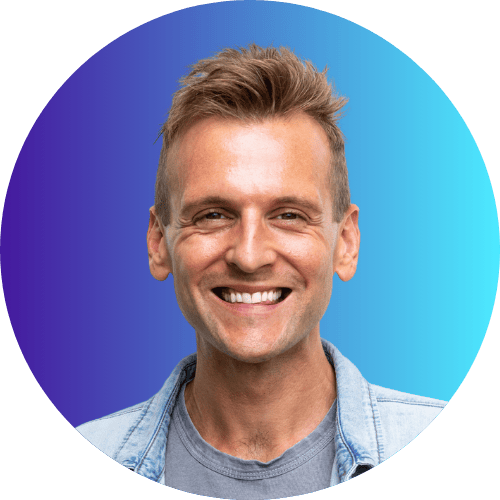 Kaleb Wyse wearing denim shirt standing in front of ombre dark blue to light blue background.