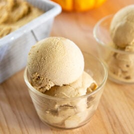 Two scoops of pumpkin ice cream sit in a dish.