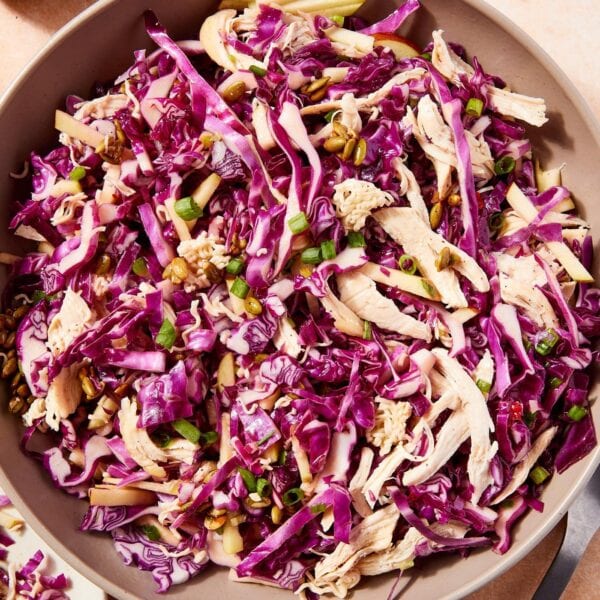 Large bowl filled with ramen chicken salad with purple cabbage and roasted shredded chicken.
