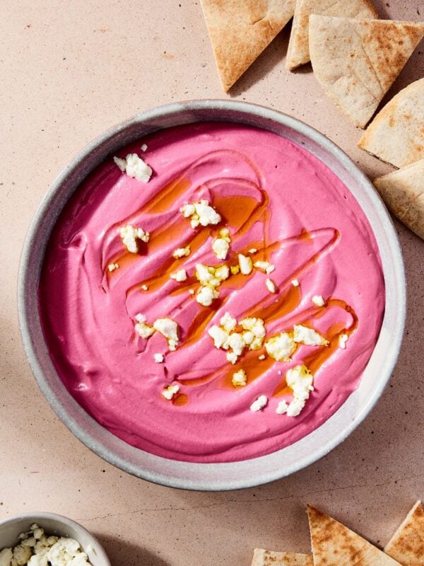 A bowl of beet hummus on a table.