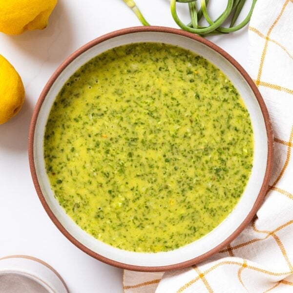 A bowl of chimichurri sauce on a table.