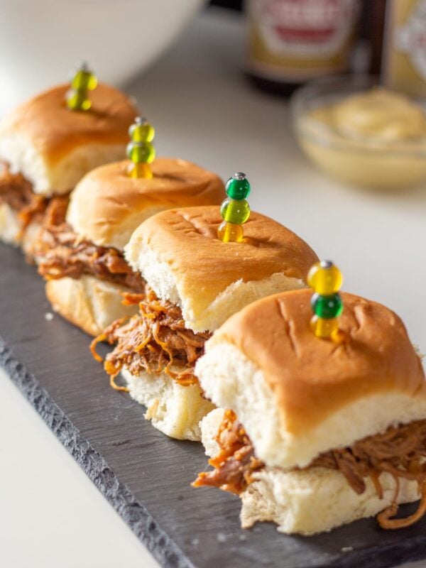Pulled pork sliders sit on a serving stone.