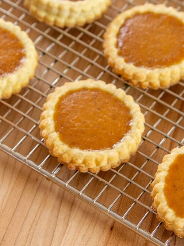 Pumpkin pie cookies rest on a cooling rack.