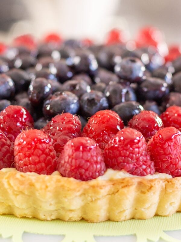 Raspberries and blueberries on top of a tart.