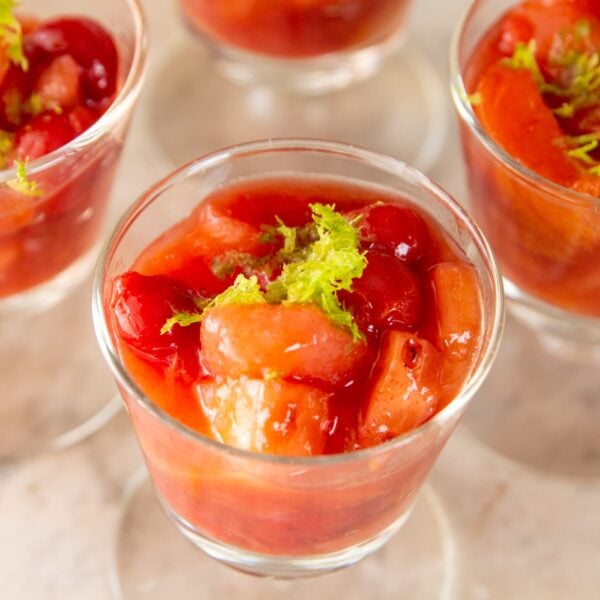 A glass cup full of fruit.