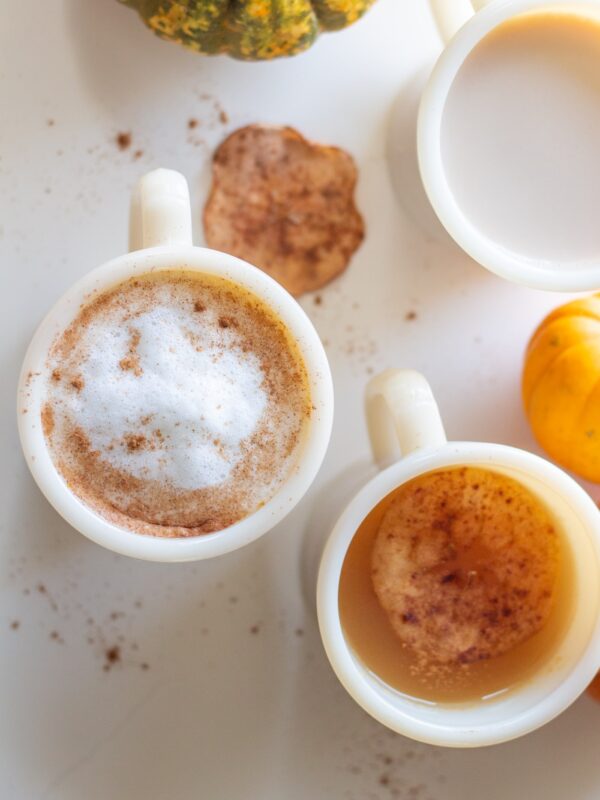Mugs full of various flavored drinks sit on a table.