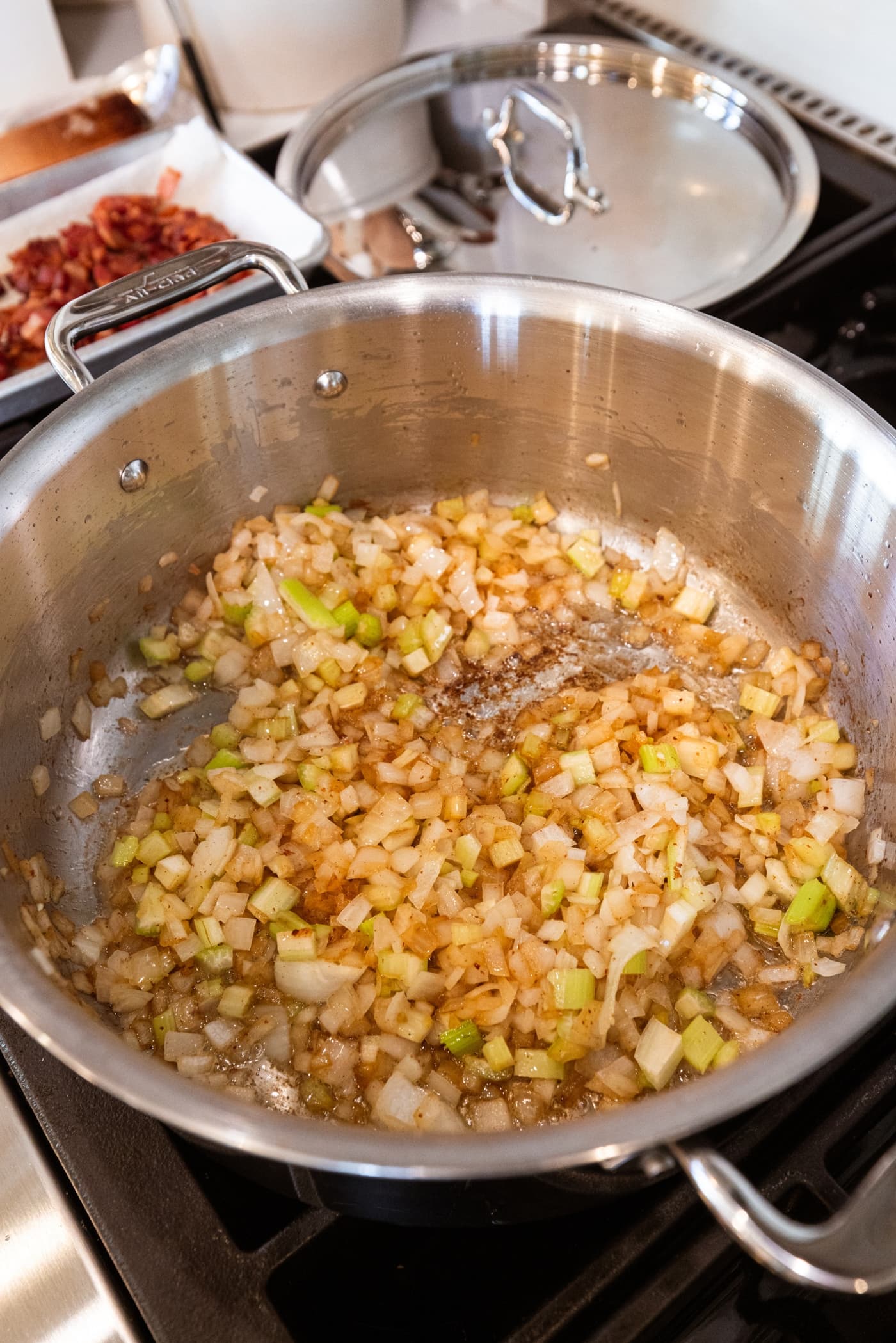 Large stockpot filled with browned cooked onion and celery after being on the heat.