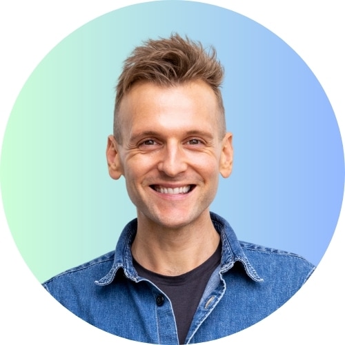 Kaleb Wyse wearing denim shirt standing in front of light blue to darker blue ombre background.