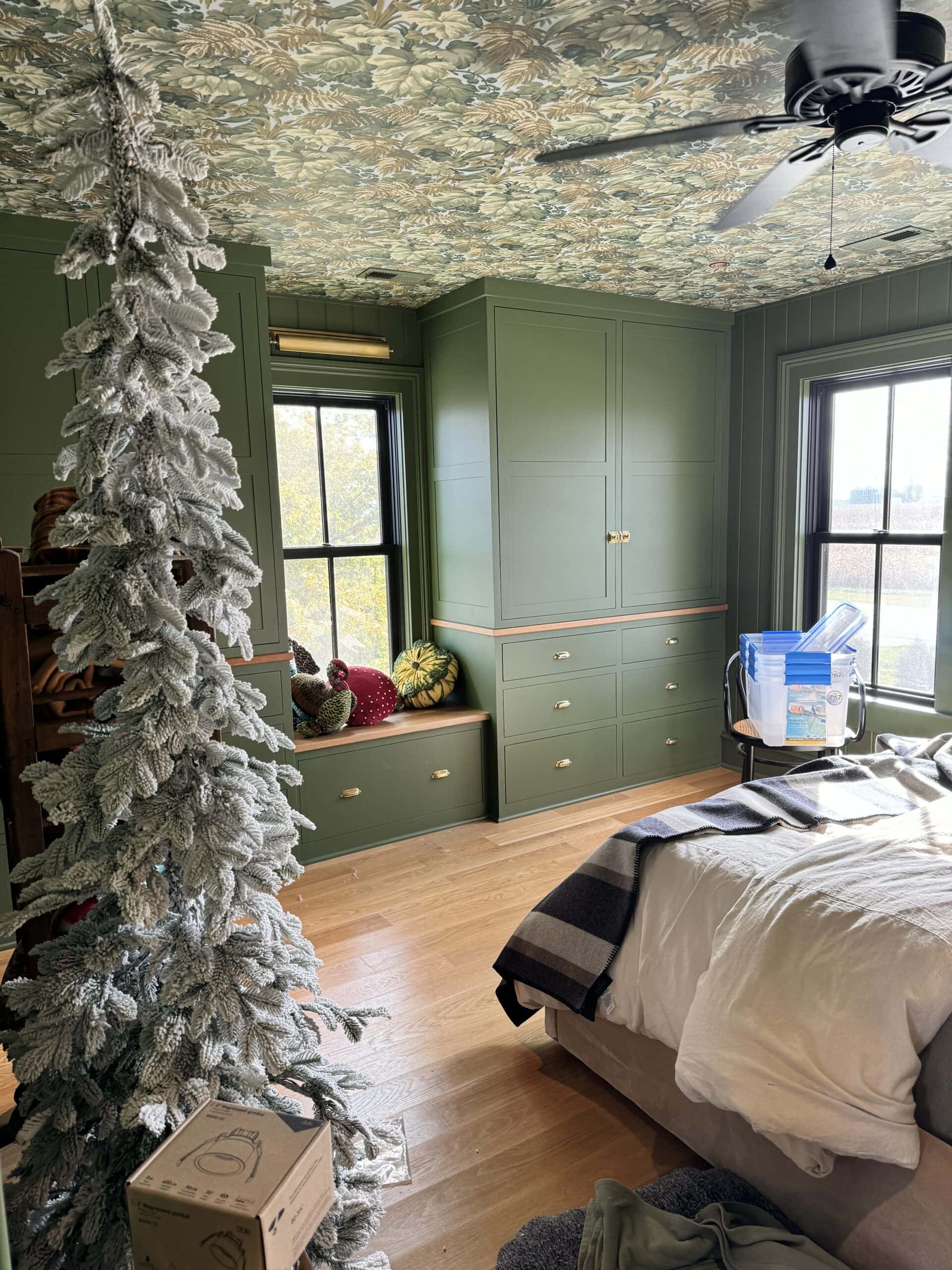 Upstairs bedroom in all green with lots of boxes sitting around being decorated for the Christmas season.