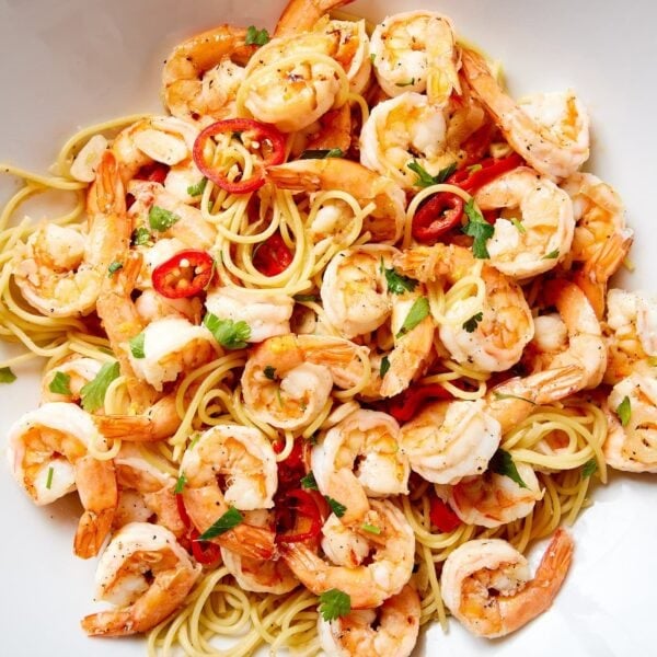 Large white bowl filled with garlic shrimp pasta with chiles and spaghetti.