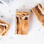 Three slices of peanut butter fingers showing chocolate and peanut butter swirls on marble surface.