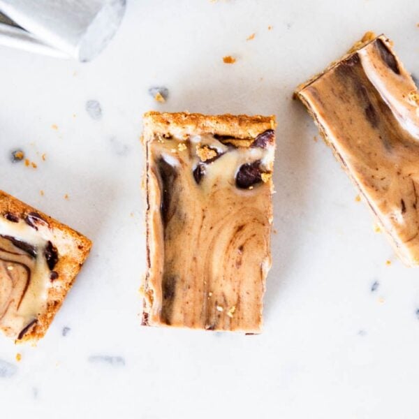 Three slices of peanut butter fingers showing chocolate and peanut butter swirls on marble surface.