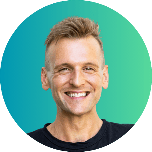 Kaleb Wyse wearing black shirt smiling and standing in front of ombre blue to green background.