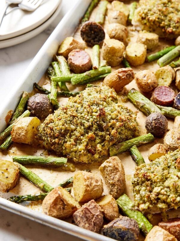 Sheet pan with herb crusted baked halibut with roasted potatoes and asparagus on sheet pan as well.