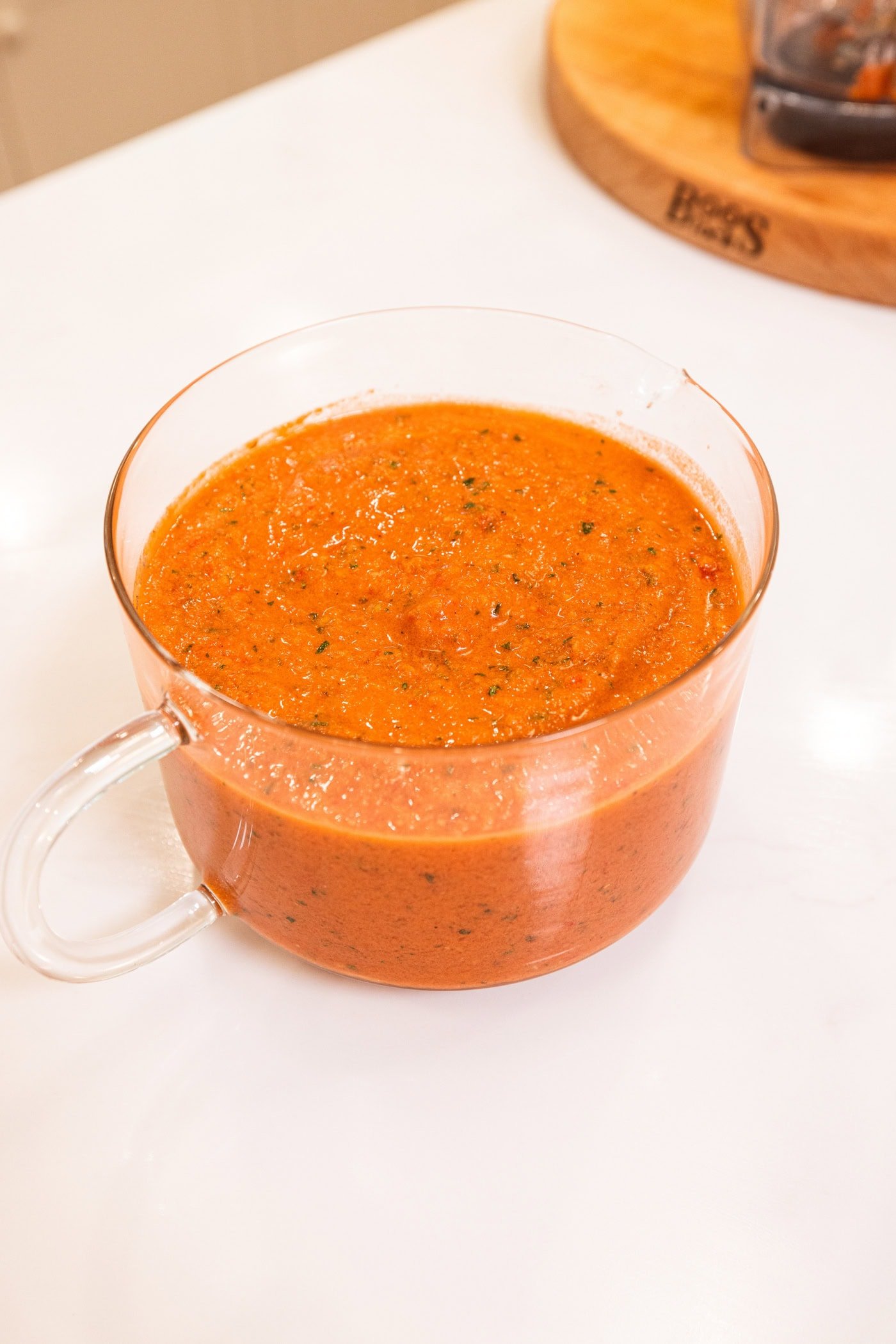 Measuring cup with gazpacho sitting in it after chilling in the refrigerator.