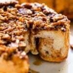 White plate with sticky buns recipe with two rolls missing showing the dough interior of the buns.