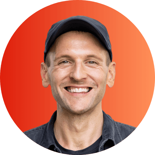 Kaleb Wyse wearing black hat standing in front of orange to red ombre background.