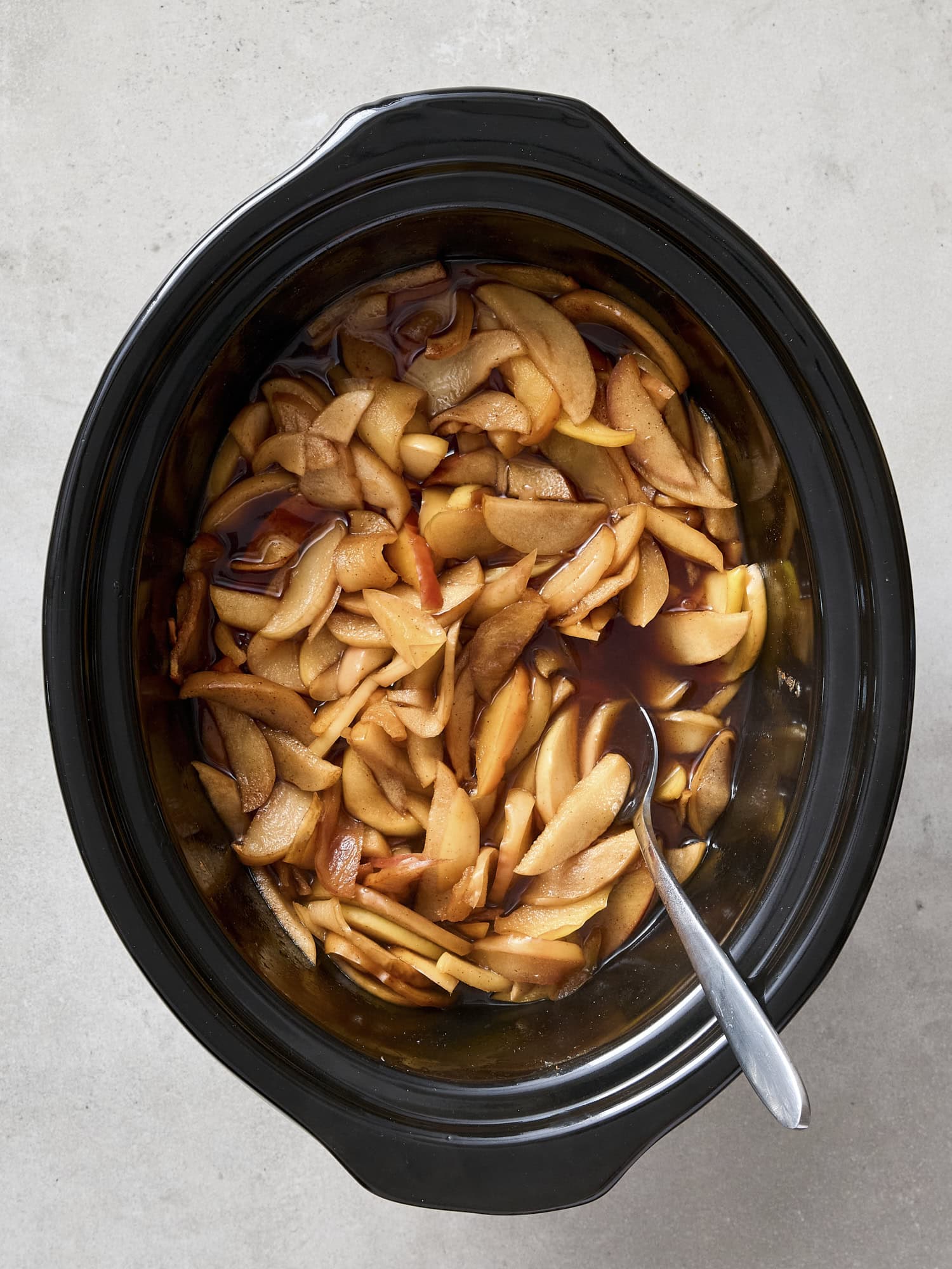 Slow cooker with browned apple mixture after cooking.