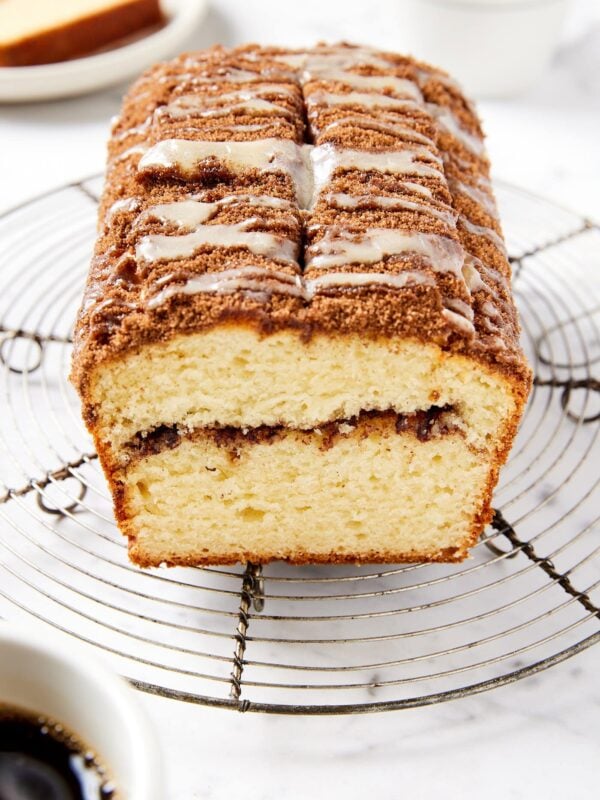 Marble surface with loaf of sour cream coffee cake showing a cinnamon interior layer.