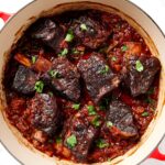 Braised short ribs sit in a Dutch oven after cooking.
