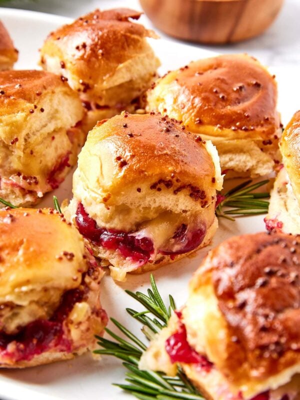 A spread of holiday sliders with cranberry sauce and Dijon mustard.