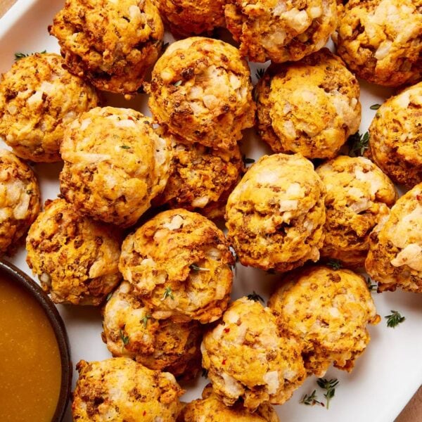 White platter filled with sweet potato puffs with fresh herbs sprinkled on top.