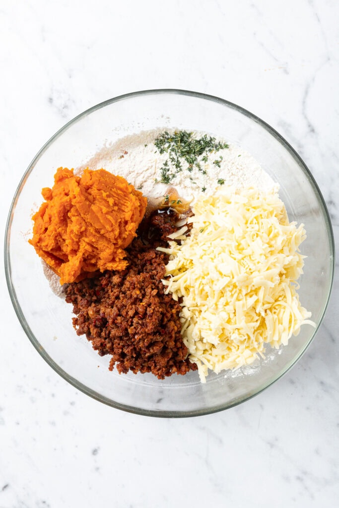 Ingredients to make sausage and sweet potato puffs in a bowl before combining.
