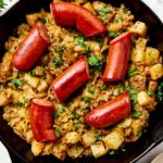 Sauerkraut, potatoes, and onion in an iron skillet with kielbasa.
