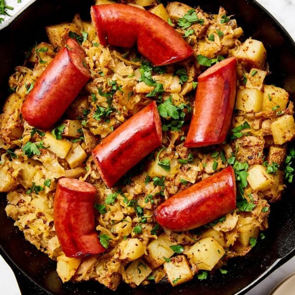 Sauerkraut, potatoes, and onion in an iron skillet with kielbasa.
