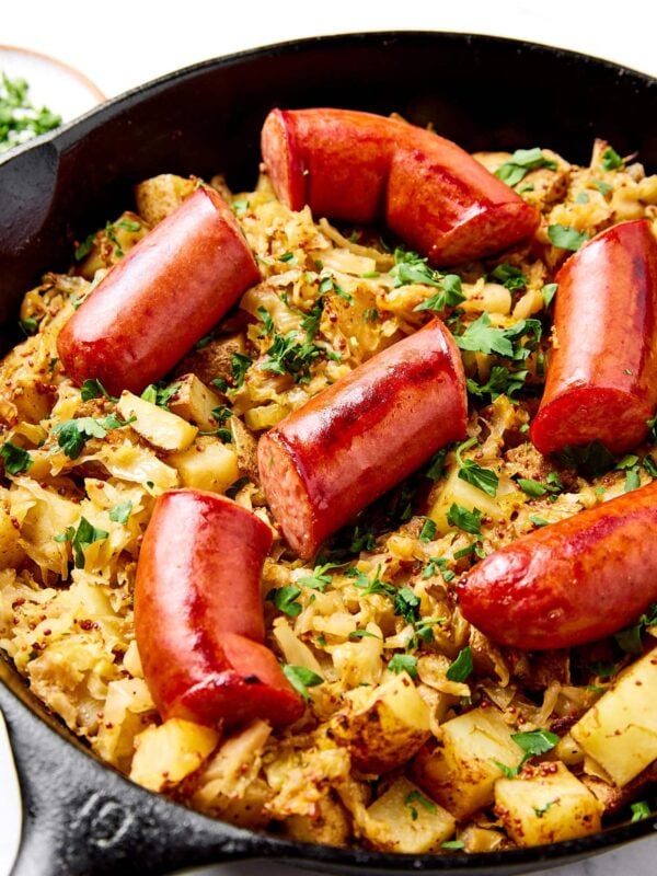 Kielbasa, sauerkraut, and potatoes in an iron skillet after roasting.