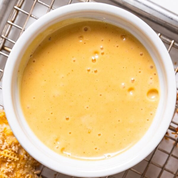 White bowl filled with honey mustard sauce sitting on a wire cooling rack.
