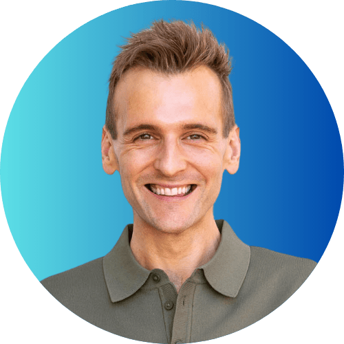 Kaleb Wyse standing in front of blue background wearing a green shirt.