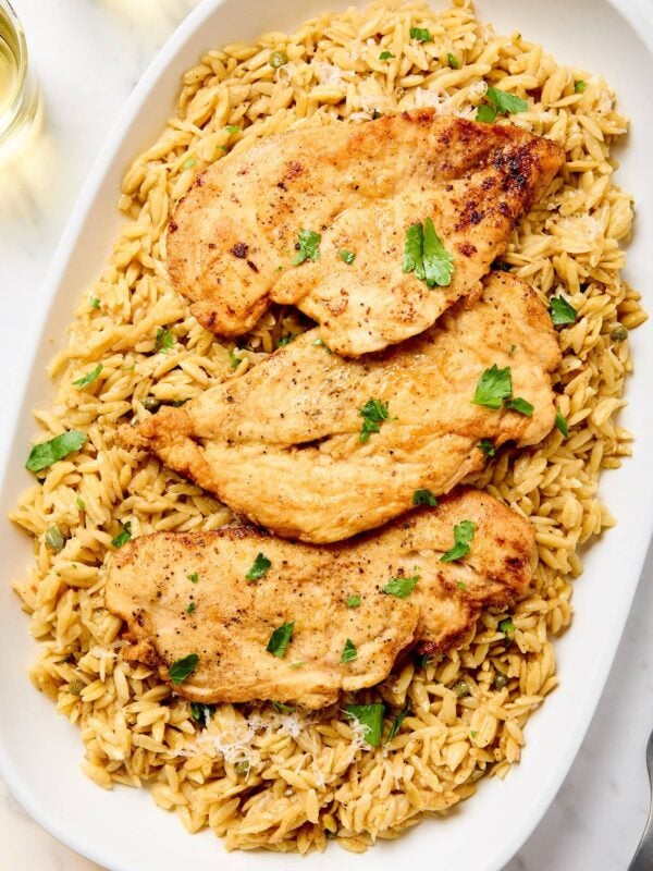 Chicken piccata with orzo on a platter.