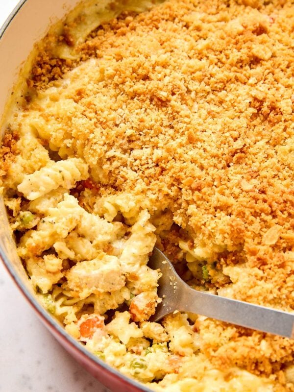 Scooping out chicken pot pie casserole from a pot.