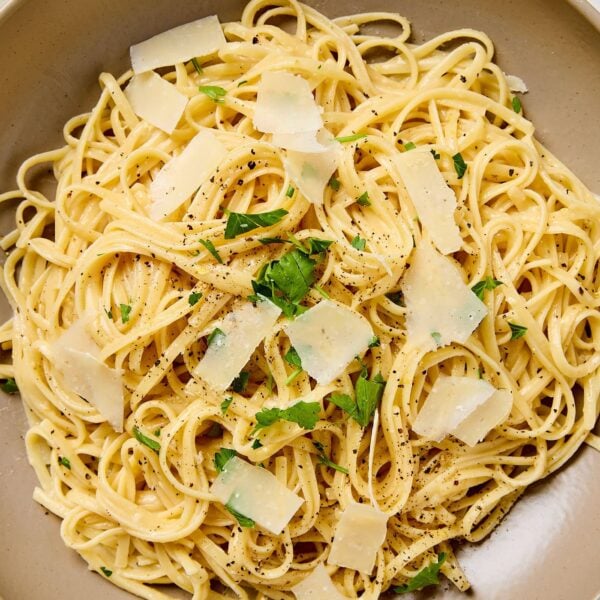 Lemon butter pasta topped with parsley and Parmesan cheese in a bowl.