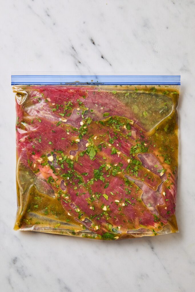 Flank steak in plastic bag with marinade.