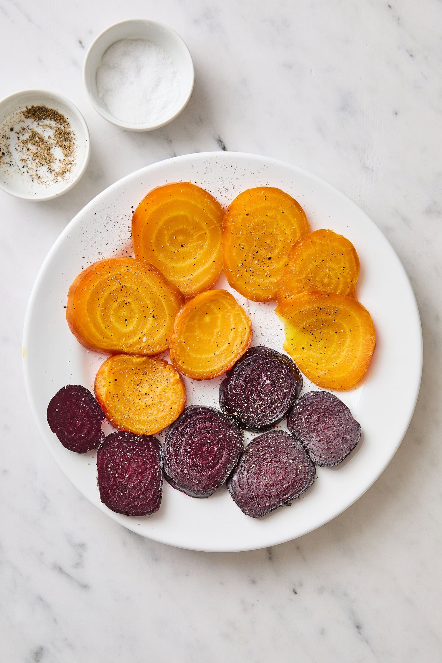 Plate with sliced beets in both red and gold color after being salted.