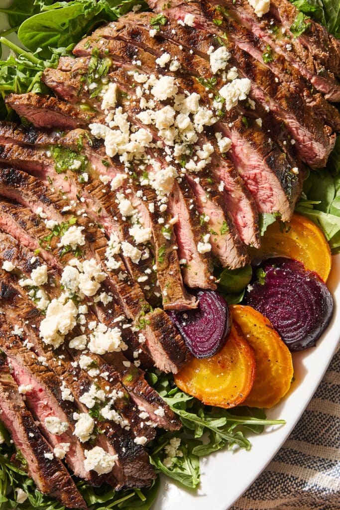 Steak salad with crumbled blue cheese and green dressing and beets.