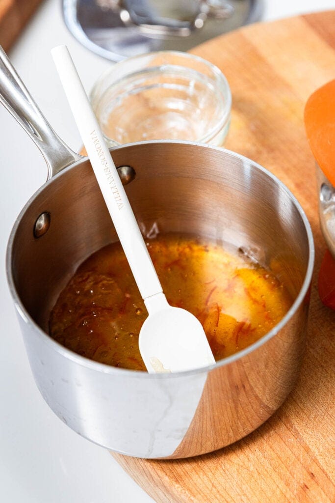 Orange marmalade and honey forming the base for a glaze in a saucepan.