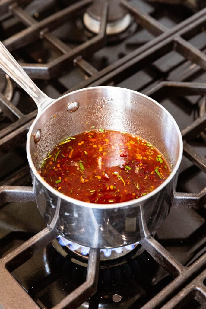 Orange chipotle glaze for ham simmering over the stove.