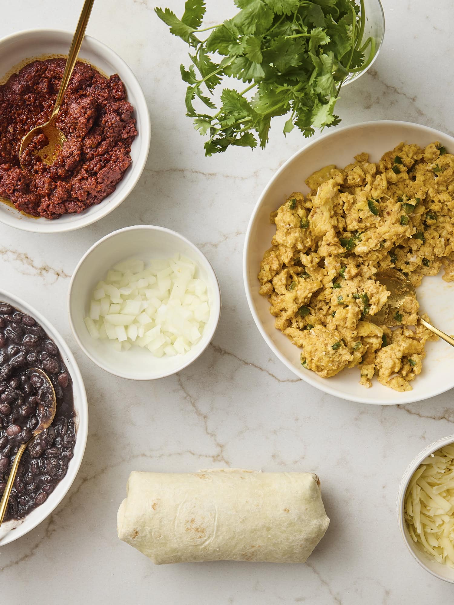 Assembled burrito with ingredients for inside all around.