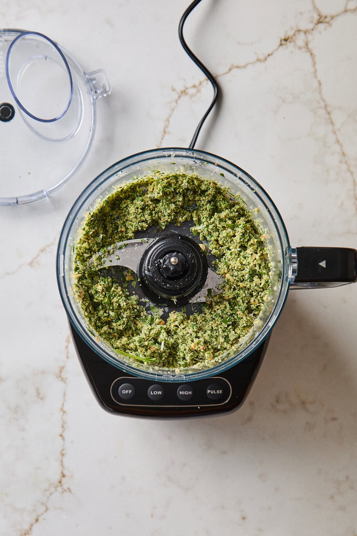 Roughly chopped up ingredients for basil pesto before olive oil.