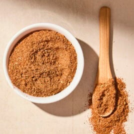 White bowl filled with homemade taco seasoning blend with more on spoon.