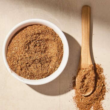 White bowl filled with homemade taco seasoning blend with more on spoon.