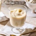 Dessert glasses on surface filled with homemade vanilla pudding.