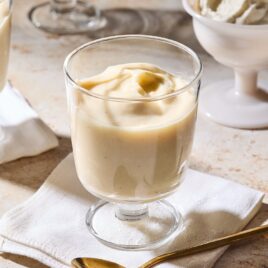Dessert glasses on surface filled with homemade vanilla pudding.