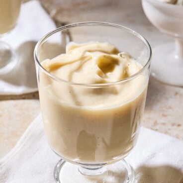 Dessert glass filled with homemade vanilla pudding with swirl on top.