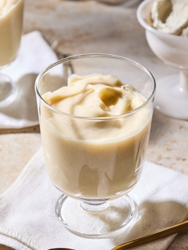 Dessert glass filled with homemade vanilla pudding with swirl on top.
