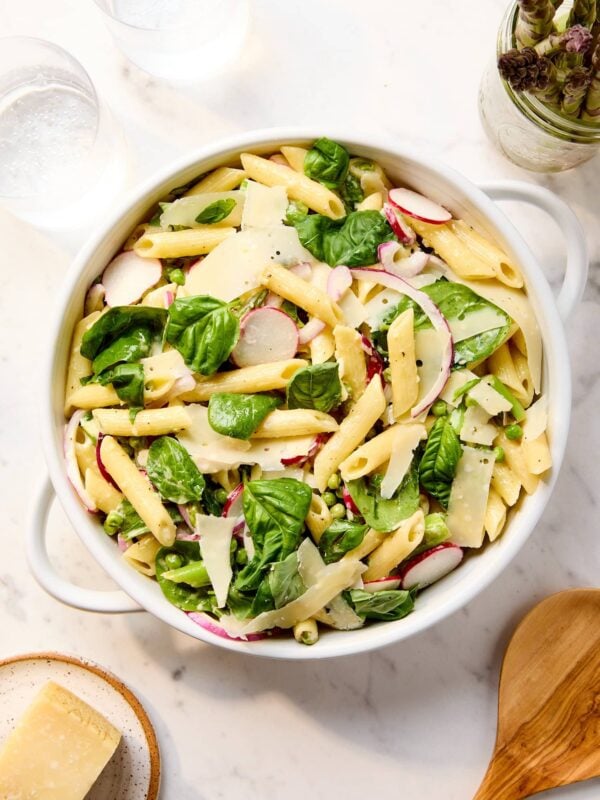 Primavera pasta salad in a serving bowl on a marble counter.