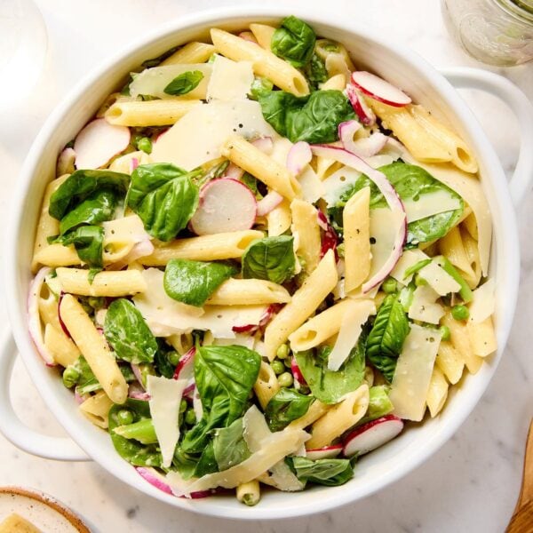 Primavera pasta salad in a serving bowl on a marble surface.